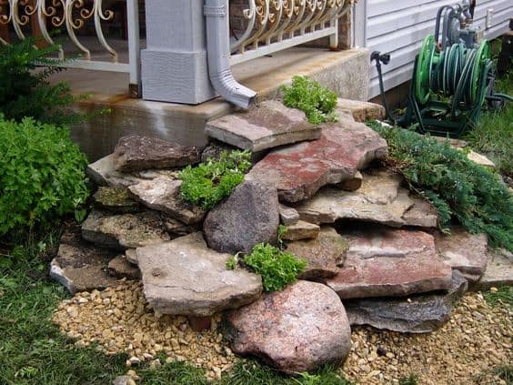 dry creek bed under waterfall downspout